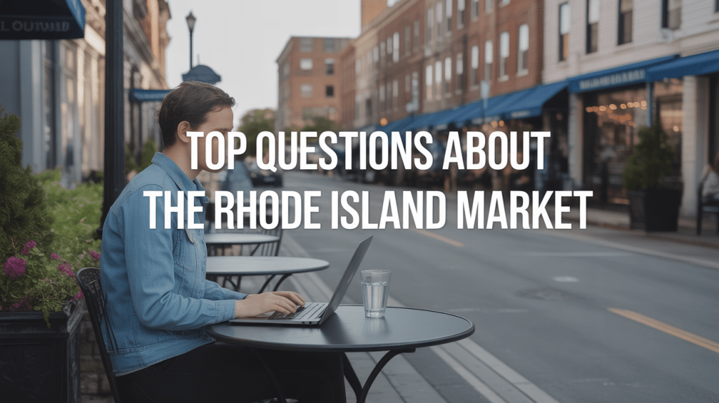 Person using a laptop at an outdoor caf&eacute; table with a glass of water, with a street view in the background featuring shops and buildings, overlaid with text about questions on the Rhode Island market.
